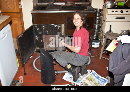 Femme de nettoyer un combustible solide de cuisson, Hampshire, Angleterre, Royaume-Uni. Banque D'Images