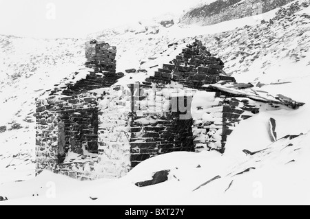 Un bâtiment abandonné dans la carrière d'ardoise Dinorwic en hiver. Image en noir et blanc Banque D'Images