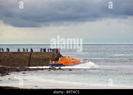 Les gens qui regardent la ville de Londres de la RNLI lifeboat III étant lancé à Sennen à Cornwall. Banque D'Images