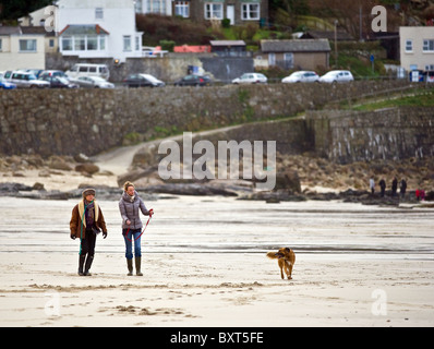 Les gens marchent en ddog sur la plage de Sennen, dans les Cornouailles. Banque D'Images