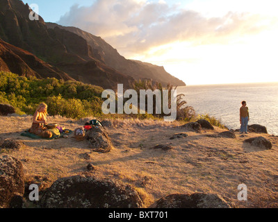 Près d'une femme, ou le site heiau ancient temple Hawaiien donnant sur l'océan au-dessus de Kalalau beach, côte de Na Pali, Kauai Banque D'Images