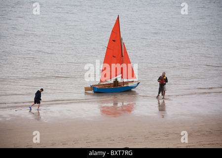 Son père et ses deux fils avec bateau à voile sur la plage de Big Sand, Gairloch. Banque D'Images