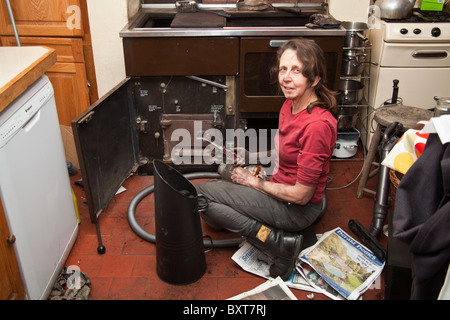 Femme de nettoyer un combustible solide de cuisson, Hampshire, Angleterre, Royaume-Uni. Banque D'Images