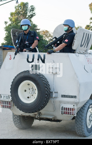 Un véhicule de l'ONU et les soldats offrent une protection à un organisme d'aide humanitaire la distribution de nourriture en Haïti. Banque D'Images