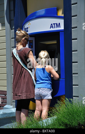 Mère et fille au distributeur automatique de la machine à la Direction générale de BNZ, Rue Balguerie, Akaroa, la péninsule de Banks, Canterbury, Nouvelle-Zélande Banque D'Images