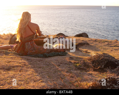 Près d'une femme, ou le site heiau ancient temple Hawaiien donnant sur l'océan au-dessus de Kalalau beach, côte de Na Pali, Kauai Banque D'Images