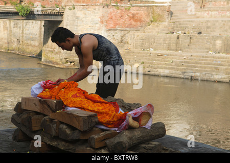 Un fils dit au revoir à un salon funéraire crémation sur la rivière Bagmati au Temple d'Pahsupatinath à Katmandou, Népal Banque D'Images