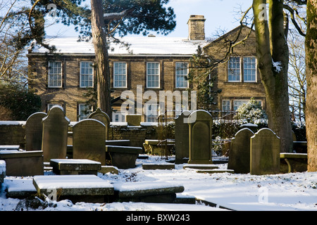 Bronte Parsonage Museum, Haworth, West Yorkshire avec le cimetière, dans la neige Banque D'Images