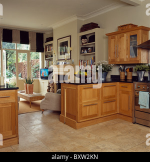 Carrelage en pierre calcaire et bois clair d'unités en cuisine et salle de séjour avec la crème noir +stores rayés Banque D'Images