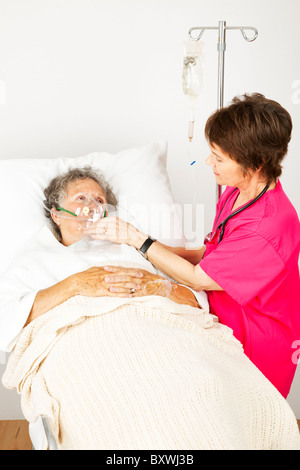 Femme senior à l'hôpital avec une maladie pulmonaire, l'obtention de l'oxygène d'une infirmière. Banque D'Images