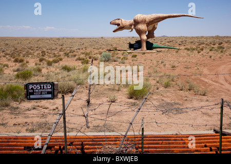 USA, Arizona, Holbrook, Sculpture de combattre les dinosaures sur dusty desert road dans le désert près de l'historique Route 66 au matin d'été Banque D'Images