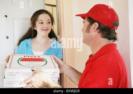 Teen girl à répondre à la porte pour recevoir les pizzas elle est commandé. Banque D'Images