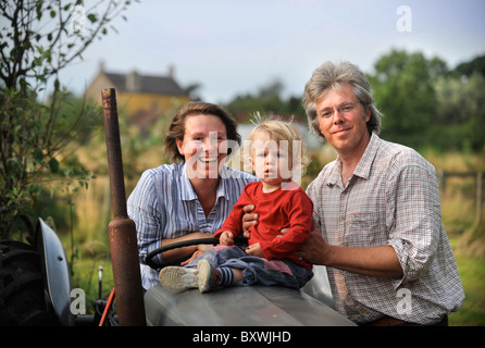 Une famille sur leurs lopins de terre avec un vieux tracteur agricole commune Fleurs UK Banque D'Images