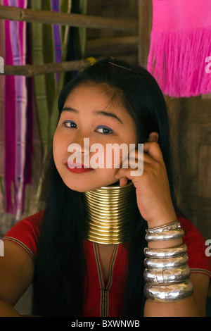 Une femme réfugiée Karen Paduang portant des anneaux d'or autour de son cou est relaxant à son domicile dans un camp de réfugiés birmans en Thaïlande. Banque D'Images