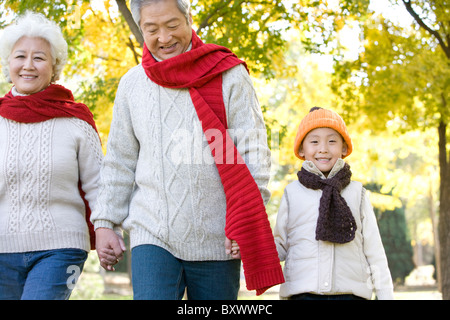 Les grands-parents et petit-fils de marcher dans un parc en automne Banque D'Images