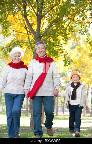 Les grands-parents et petit-fils de marcher dans un parc en automne Banque D'Images