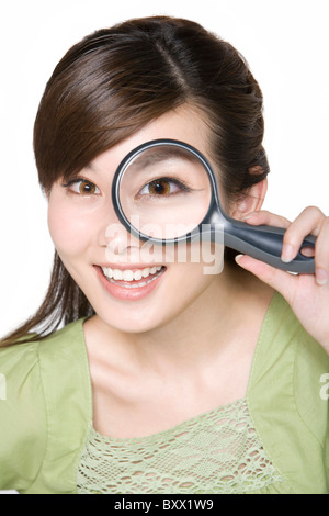 Portrait de jeune femme à la loupe à travers Banque D'Images