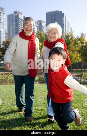 Les grands-parents et petit-fils bénéficiant d'un parc à l'automne Banque D'Images