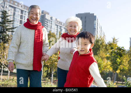 Les grands-parents et petit-fils bénéficiant d'un parc à l'automne Banque D'Images