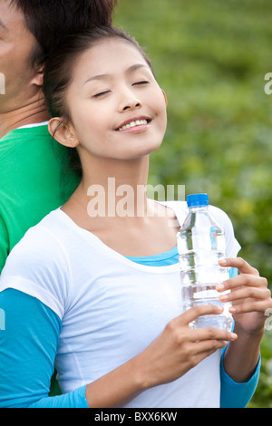 Jeune femme dans un champ de thé tenant une bouteille d'eau Banque D'Images