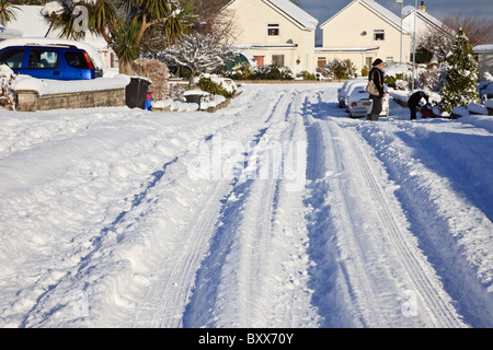 De profondes ornières de traces de pneu dans la neige sur la rue de banlieue après de fortes chutes de neige d'hiver en 2010. Pays de Galles Royaume-uni Grande-Bretagne Banque D'Images