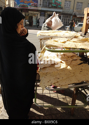 Femme acheter du pain dans une boulangerie, Shiraz, Iran Banque D'Images