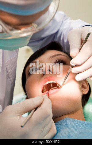 Close-up of woman avec la bouche ouverte en cours d'examen par l'hygiéniste dentaire Banque D'Images