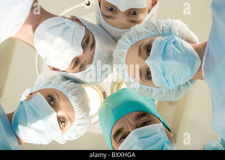 Vue de dessous des chirurgiens masqués looking at camera Banque D'Images