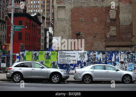 Parking voitures à côté d'un mur recouvert d'affiches et des publicités sur la sixième avenue dans le quartier chinois, la ville de New York, 2010 Banque D'Images