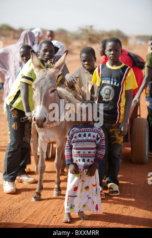 Dans le nord du Burkina Faso, les enfants de leur village, voyage au marché hebdomadaire le mercredi à Djibo sur un âne. Banque D'Images