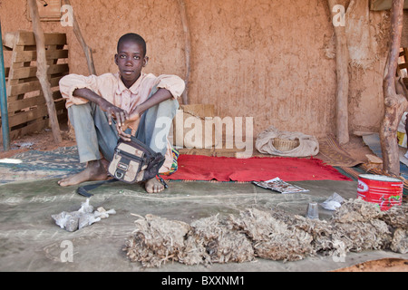 Dans la ville de Djibo, au nord du Burkina Faso, un garçon vend du tabac sur le marché. Banque D'Images