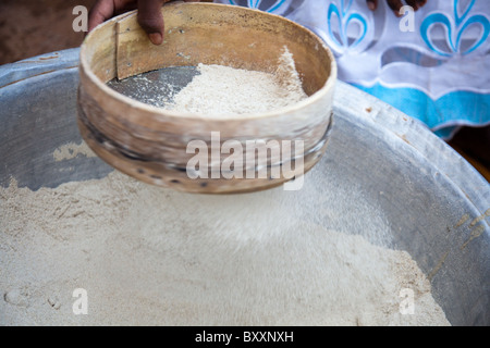 Une femme prépare la farine de mil pour la cuisson dans la ville de Djibo dans le nord du Burkina Faso. Banque D'Images