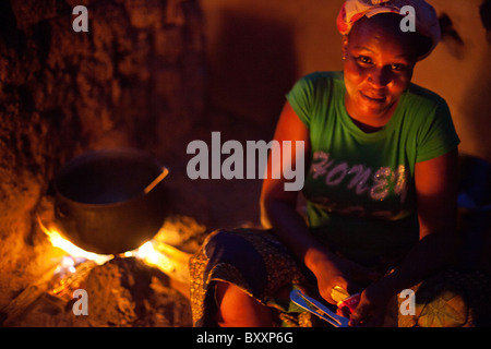 Sans électricité ou de gaz, une femme à Djibo dans le nord du Burkina Faso, cuisiniers dîner en plein air sur un feu ouvert. Banque D'Images