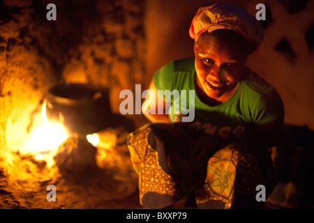 Sans électricité ou de gaz, une femme à Djibo dans le nord du Burkina Faso, cuisiniers dîner en plein air sur un feu ouvert. Banque D'Images