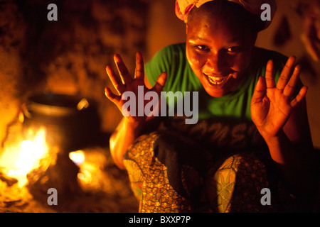 Sans électricité ou de gaz, une femme à Djibo dans le nord du Burkina Faso, cuisiniers dîner en plein air sur un feu ouvert. Banque D'Images