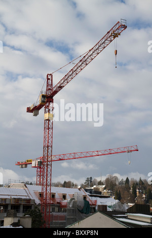 Grues de construction contre des nuages blancs. Banque D'Images