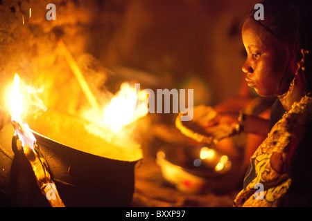 Une femme à Djibo, Burkina Faso cuisiniers millet, 'pot' similaire à la polenta Italienne sur un feu en plein air. Banque D'Images