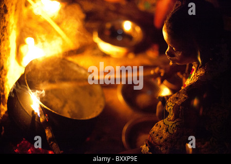 Une femme à Djibo, Burkina Faso cuisiniers millet, 'pot' similaire à la polenta Italienne sur un feu en plein air. Banque D'Images