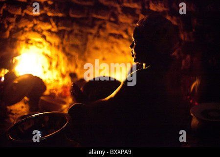 Sans électricité ou de gaz, une femme à Djibo dans le nord du Burkina Faso, cuisiniers dîner en plein air sur un feu ouvert. Banque D'Images