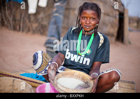 Dans le village Peul distant de Pete Goonga dans le nord du Burkina Faso, une femme prépare la farine de mil pour la cuisson. Banque D'Images