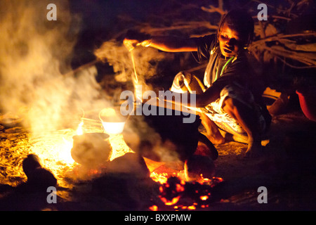 Dans le village Peul distant de Pete Goonga dans le nord du Burkina Faso, une femme prépare le dîner sur un feu ouvert. Banque D'Images