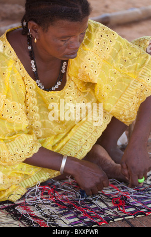 Une femme peule dans la ville de Djibo dans le nord du Burkina Faso, tisse un matelas de paille. Banque D'Images