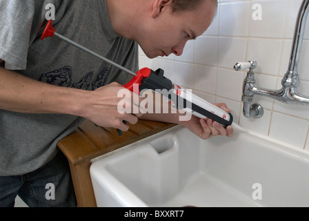 L'homme à l'aide de produit d'arme dans une cuisine Banque D'Images