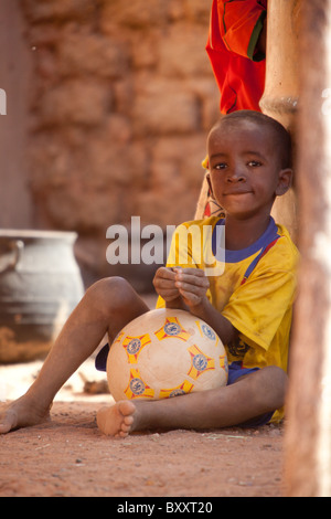 Garçon peul avec un ballon de foot dans la ville de Djibo dans le nord du Burkina Faso. Banque D'Images