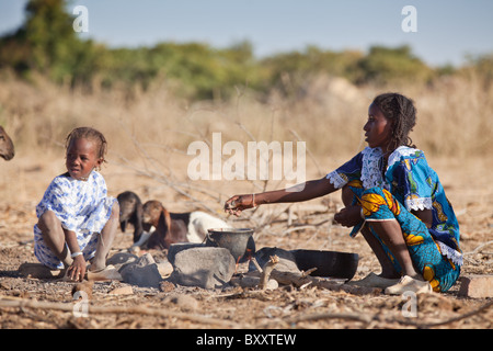 Dans le village d'Bantagiri saisonnières dans le nord du Burkina Faso, une femme Peul cuisiniers petit-déjeuner à l'extérieur sur le feu. Banque D'Images