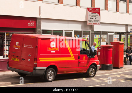 Un postier de vider une boite aux lettres près de son royal mail van à Norwich , Norfolk , Bretagne , France Banque D'Images