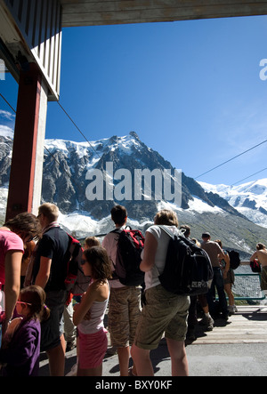 Les touristes la queue pour le téléphérique à Auguille du Midi - le pic dans la distance, Haute Savoie, Alpes, France Banque D'Images