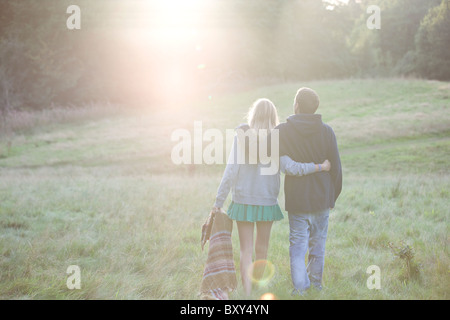 Vue arrière d'un jeune couple en train de marcher dans la campagne