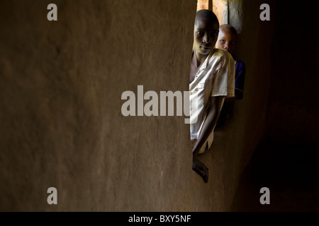 Par les pairs des enfants à travers la fenêtre d'une église à Webuye, Kenya, Afrique de l'Est. Banque D'Images