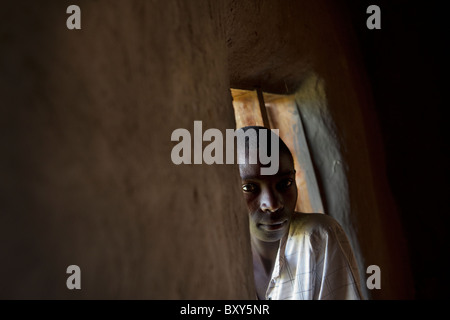 Par les pairs des enfants à travers la fenêtre d'une église à Webuye, Kenya, Afrique de l'Est. Banque D'Images